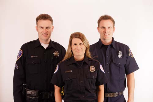 Three uniformed siblings: police officer on left, fire fighter on right, EMT in center
