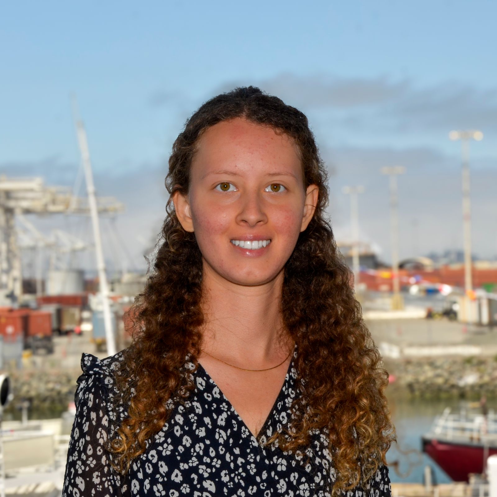 Arina Yefimova photographed against a port background on a sunny day
