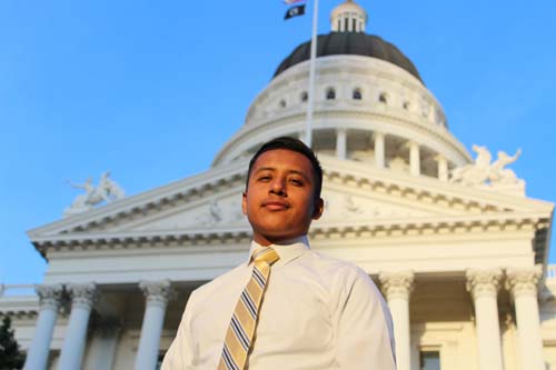 Young man in white button down in front of the Capitol dome