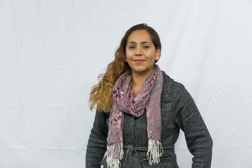 Woman in jacket and scarf against a white backdrop
