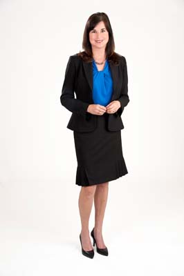 Full-length portrait of woman in business suit against a cream background