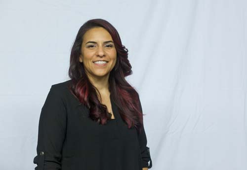 Smiling woman in black blouse against white backdrop