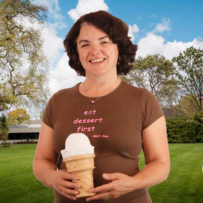 Smiling woman with oversize ice cream cone model, t-shirt reads "Eat dessert first"