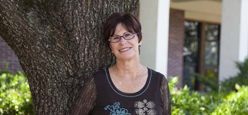 Smiling woman standing in front of a tree