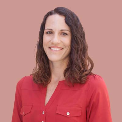 Smiling woman in red shirt against pink background