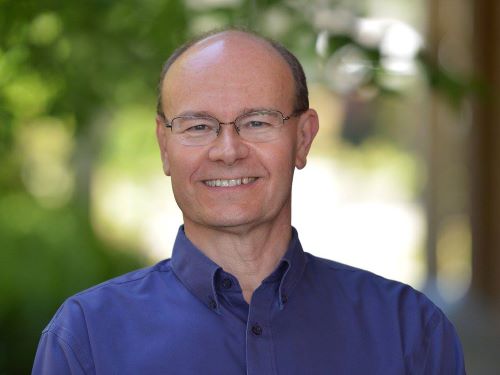 Head and shoulders portrait of a man in a blue shirt