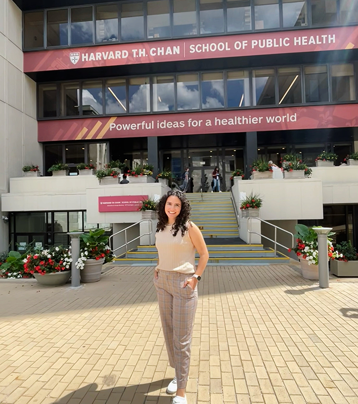 SRJC alumna Janae Briggs poses in front of the T.H. Chan School of Public Health at Harvard University